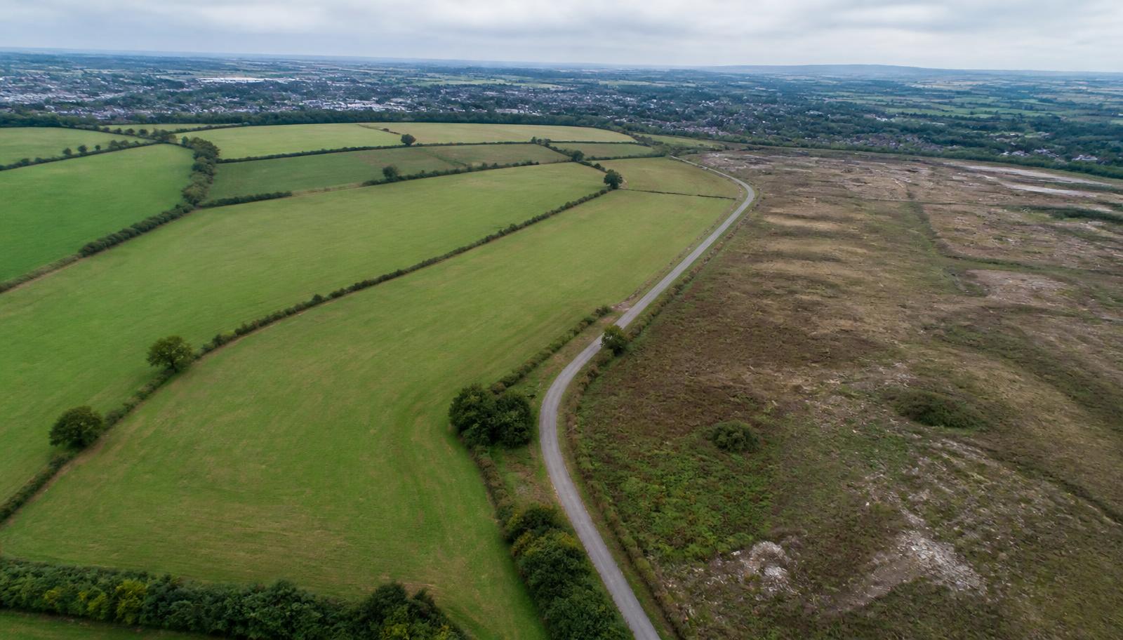 Aerial view of greenfield and brownfield land on the edge of an English town